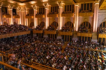A sala de concertos da Sala São Paulo está completamente cheia de pessoas sentadas e aplaudindo.