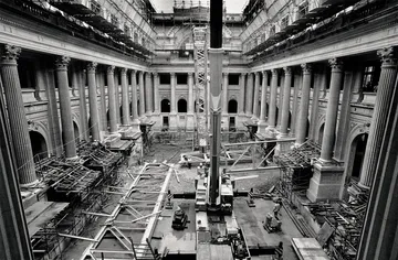 A imagem em preto e branco mostra a atual sala de concertos da Sala São Paulo em obras, com materiais de construção espalhados no chão.