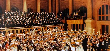 A foto mostra o concerto da Sala São Paulo no dia da inauguração. O palco está cheio de músicos com seus instrumentos. 