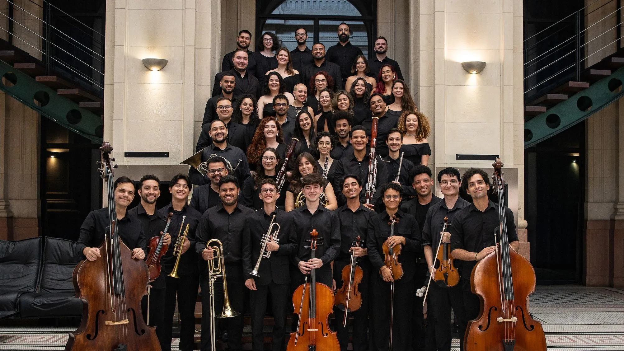 Foto das classes de canto e instrumento da Academia de Música da Osesp na escada da Sala São Paulo