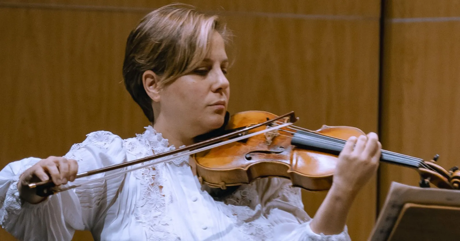 A imagem mostra uma mulher tocando violino.