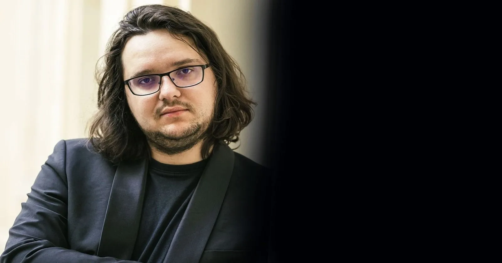 Jakub Kuszlik é um homem branco, de cabelos longos, barba e óculos.