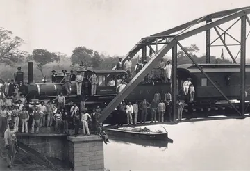 Operários da antiga estação Sorocabana posam em frente a um trem.