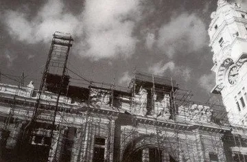 A foto em preto e branco mostra a restauração da fachada da Sala São Paulo. É possível ver uma grande estrutura de praticáveis em frente as janelas da Sala.