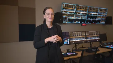 Elena Schwarz é uma mulher branca, de cabelos castanhos presos e óculos.